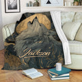 Howling wolf blanket displayed on a sofa with moon artwork and black and gold wildlife details