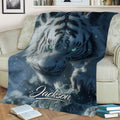 Close view of a blue tiger throw blanket with detailed fur, glowing eyes, snow, and icy scenery