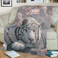 Close view of white tiger artwork with pink blossoms on a decorative throw blanket