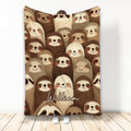 Sloth throw blanket featuring a cozy repeating pattern of smiling brown and cream sloths