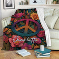 Hippie throw blanket with vibrant flowers and peace sign displayed on a sofa