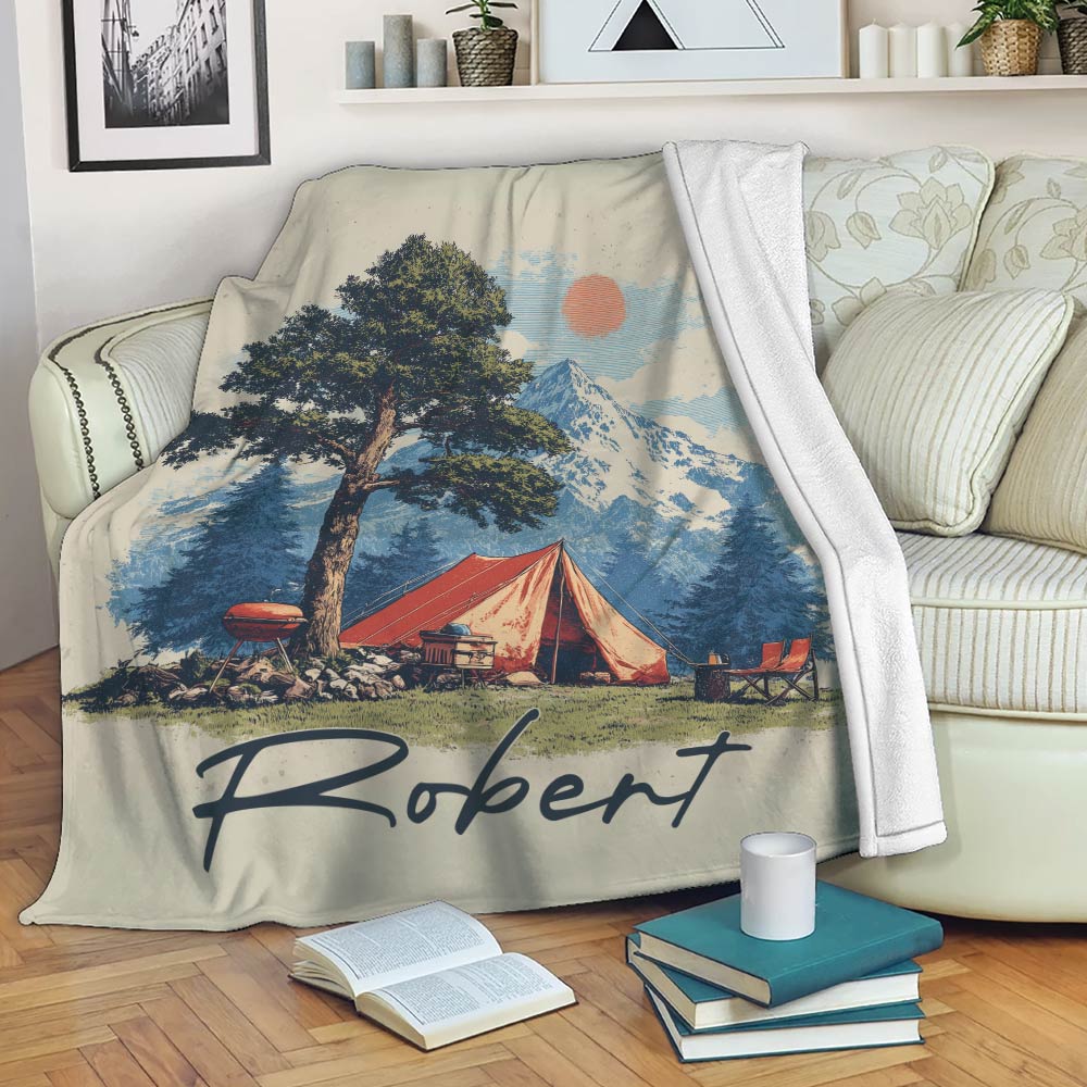 Camping throw blanket displayed on a sofa with mountain scenery, red tent and vintage outdoor artwork