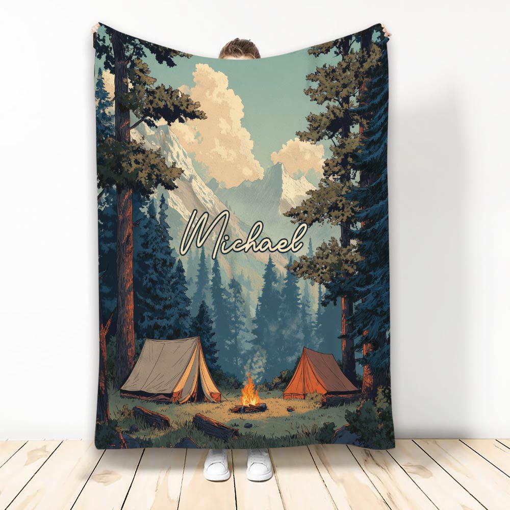 Camping blanket with mountain scenery, pine trees, tents, and a glowing campfire