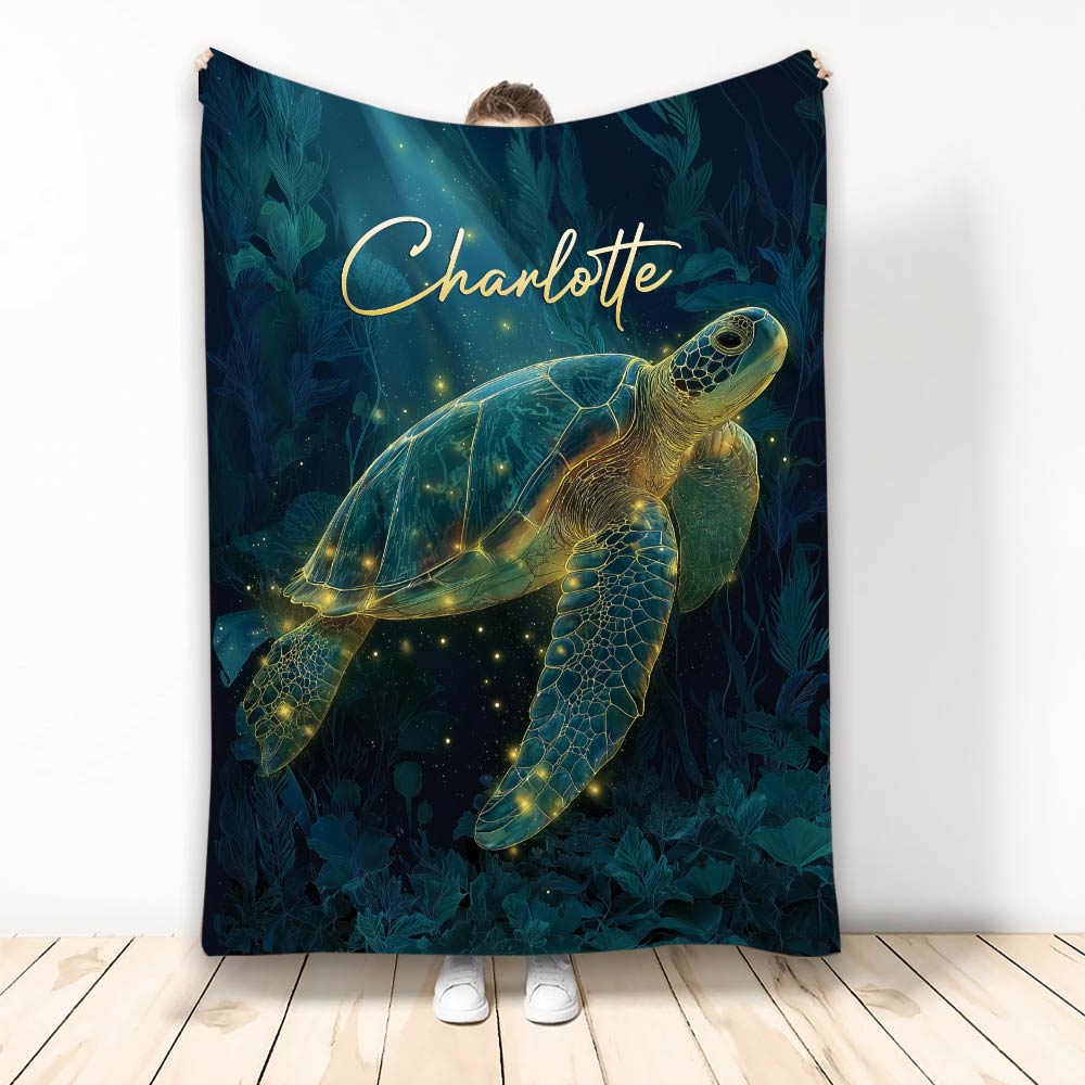 Dark teal turtle blanket featuring a glowing sea turtle swimming through leafy underwater artwork