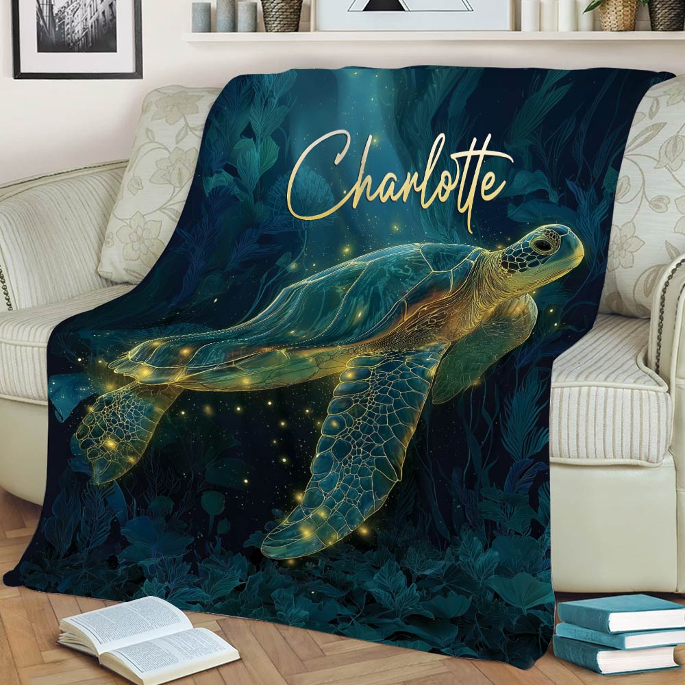 Turtle blanket styled across a couch, featuring luminous sea turtle artwork in a deep teal palette