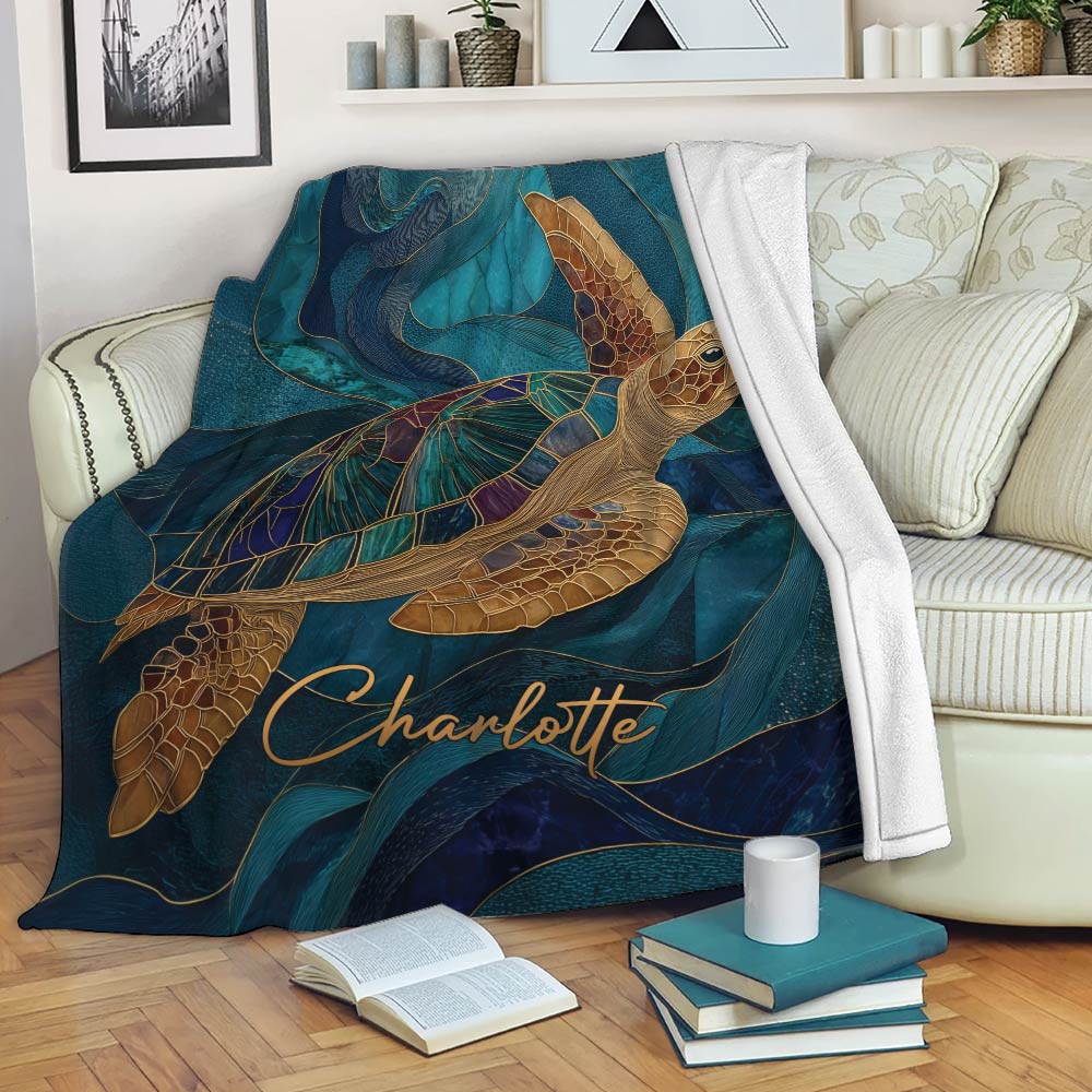Sea turtle throw blanket draped over a sofa with teal ocean artwork and a cozy reading setting