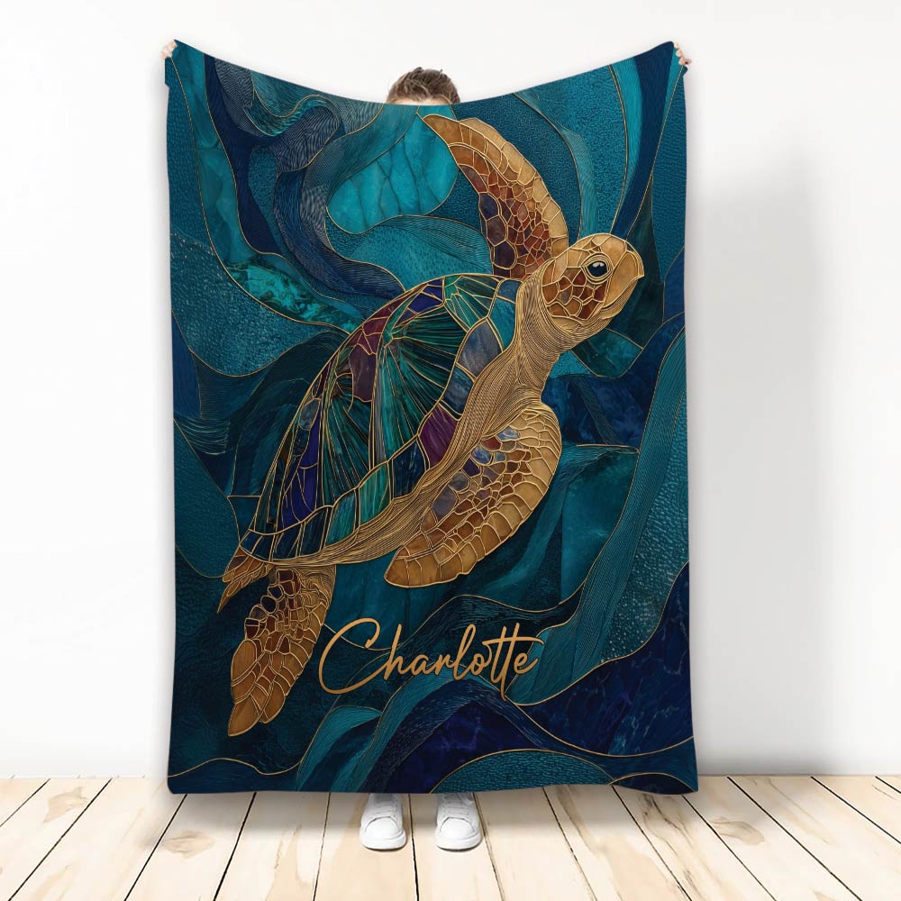 Sea turtle blanket displayed against a wall with ornate teal, navy, and gold ocean artwork