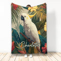 Cockatiel blanket with white cockatiel perched on a branch surrounded by lush tropical leaves and colorful hibiscus flowers