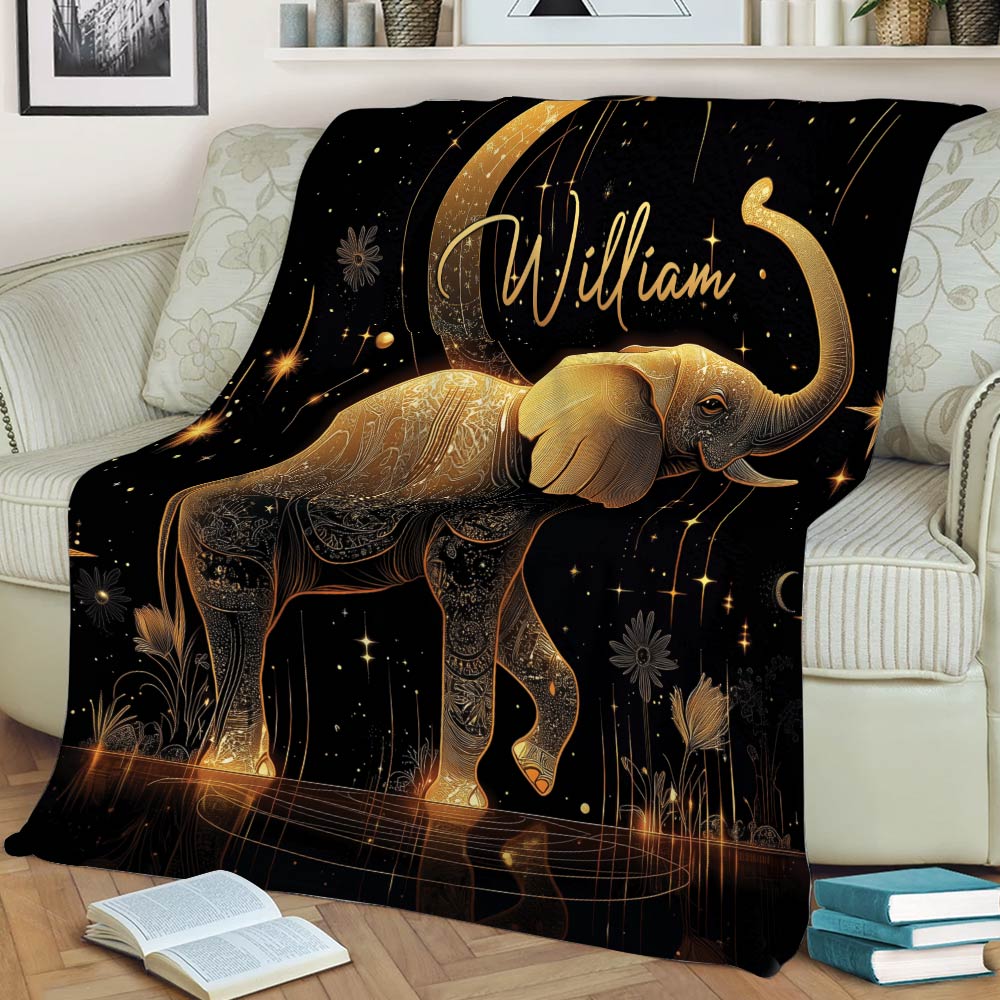 Celestial gold elephant blanket draped across a sofa with stars, moon, and botanical details