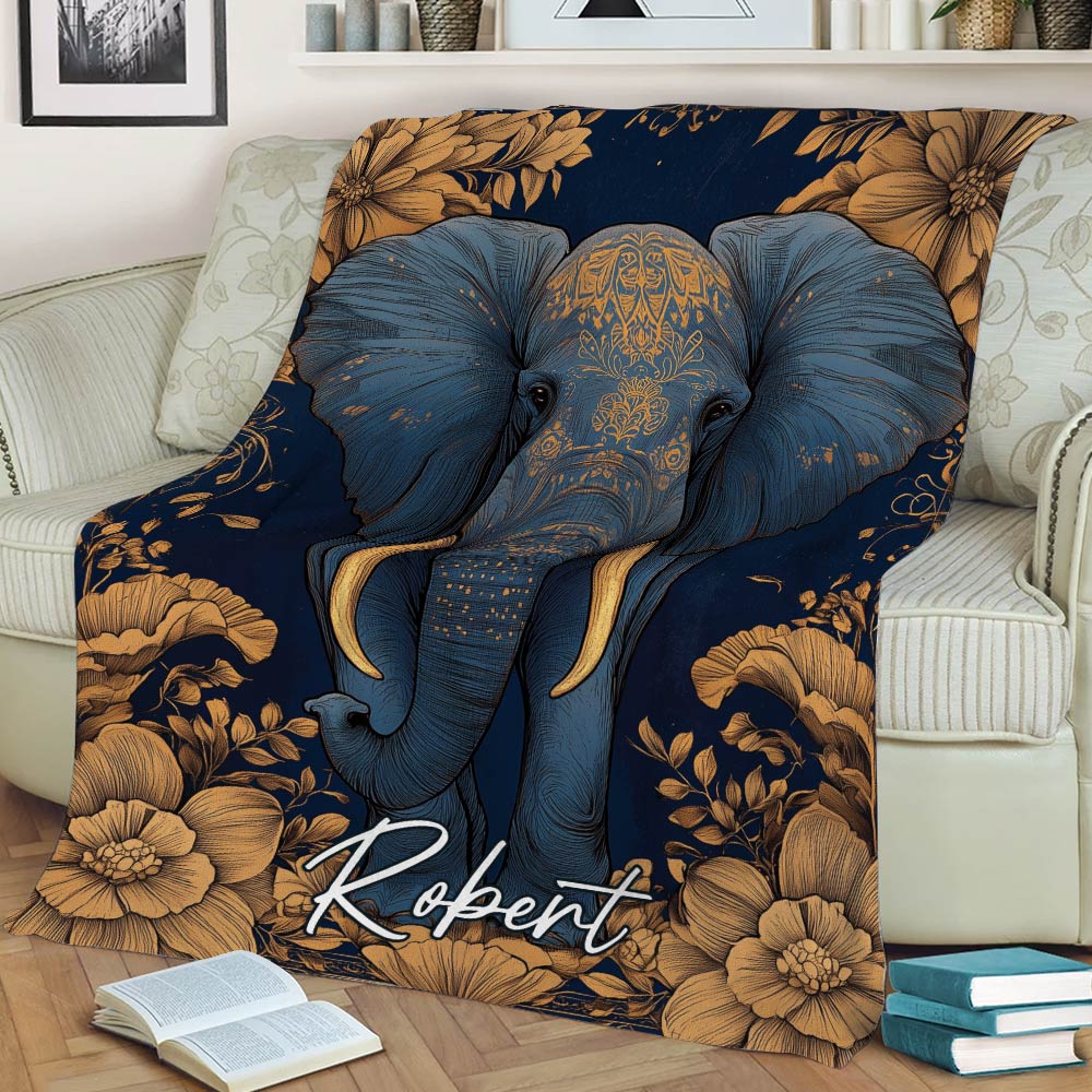 Close view of an ornate blue elephant throw blanket with golden flowers styled on a sofa