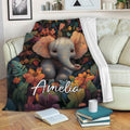 Floral elephant throw blanket draped over a sofa with books and a cup nearby