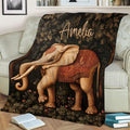 Close view of an elephant throw blanket with ornate saddle artwork and dark floral foliage