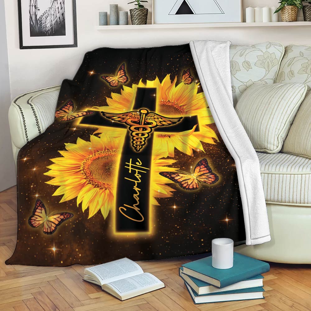 Nurse throw blanket displayed on a sofa with a caduceus cross, sunflowers, butterflies, and starry background