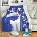 Blue nurse blanket draped over a sofa with stethoscope and medical artwork