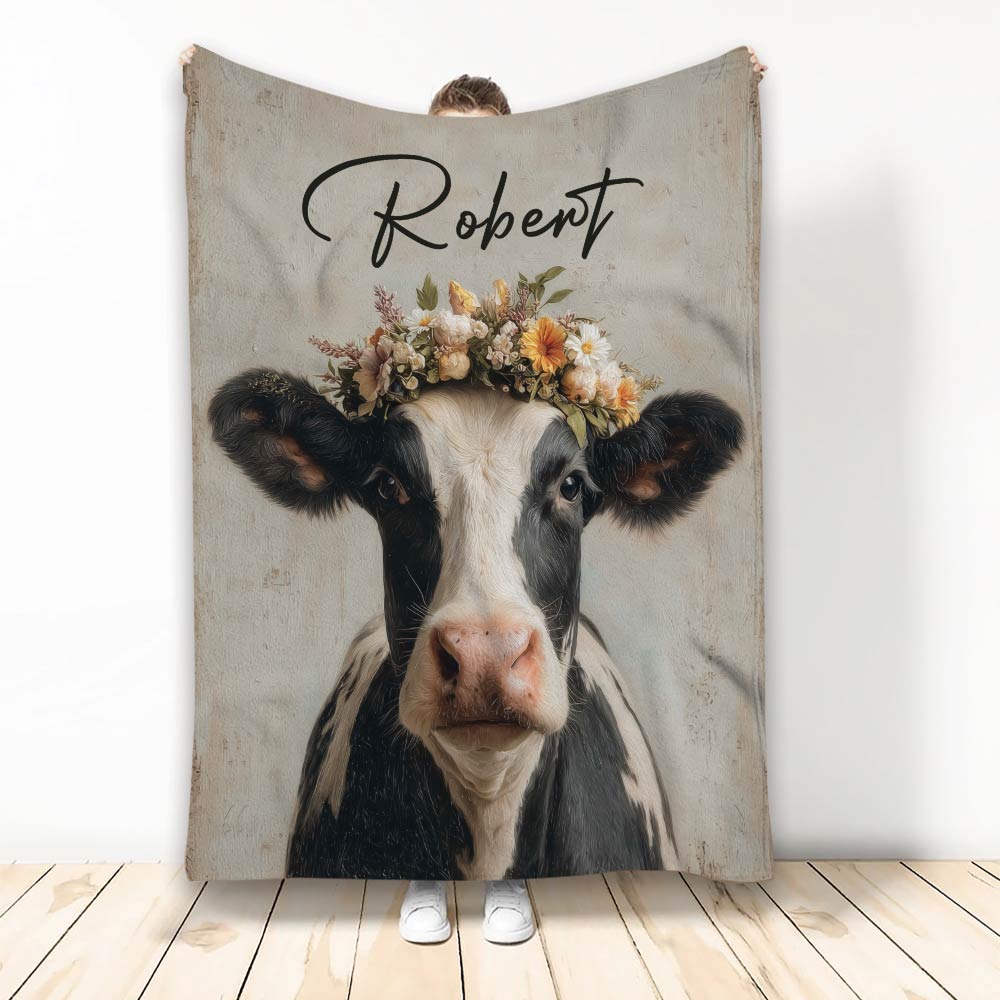 Custom cow blanket featuring a black and white cow with a colorful floral crown on a rustic background