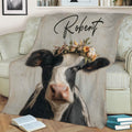 Rustic cow blanket displayed on a couch with a close-up floral-crowned black and white cow