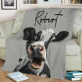 Funny cow throw blanket draped over a sofa with bold black and white farm animal artwork