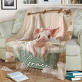 Close-up pig bath artwork blanket draped across a cozy sofa