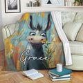 Whimsical donkey throw blanket draped over a sofa with colorful blue, yellow, and orange artwork