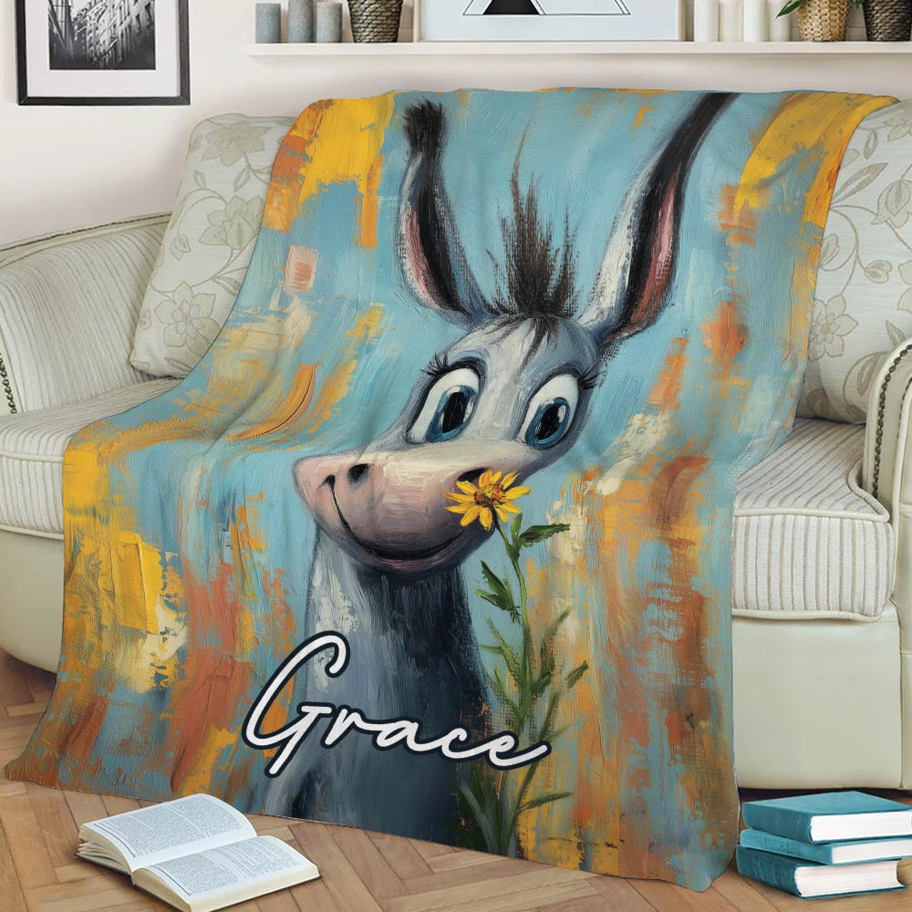 Close lifestyle view of a colorful donkey blanket displayed across a sofa with a flower detail