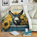 Donkey blanket draped over a sofa with sunflower artwork in a warm rustic living room