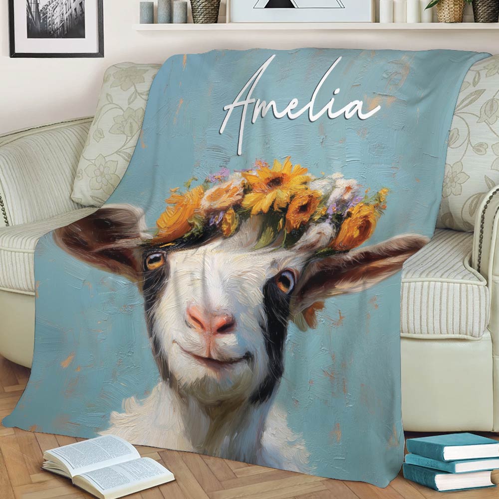 Close view of a flower-crowned goat design on a blue throw blanket over a sofa