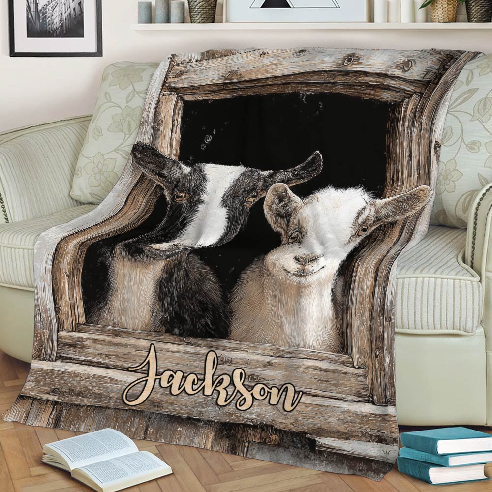 Two-goat blanket displayed across a sofa with rustic barn window artwork
