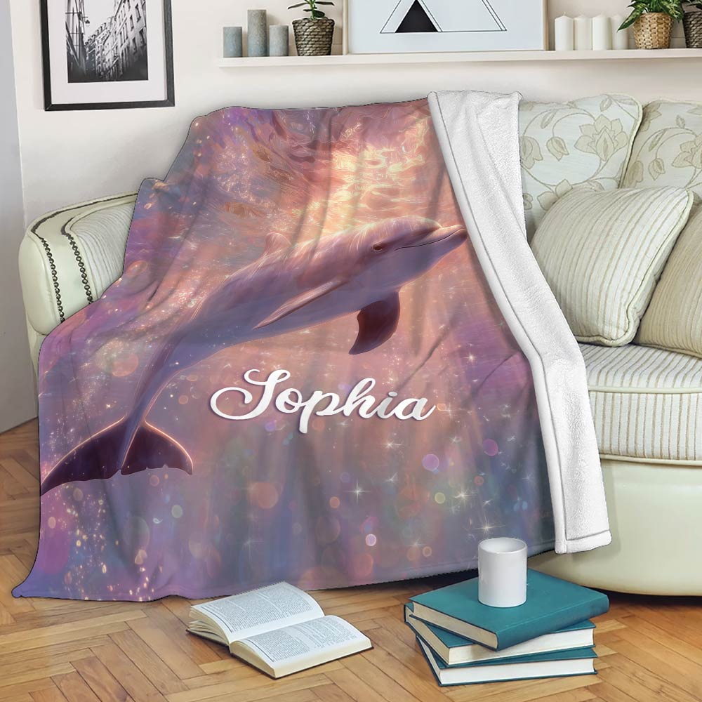 Dolphin throw blanket draped over a sofa with sparkling ocean artwork in soft pastel colors