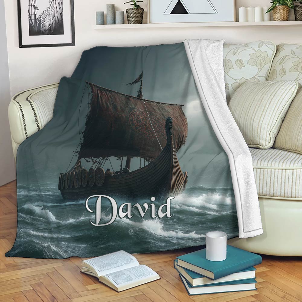 Viking blanket displayed on a sofa with dark longship artwork and stormy ocean waves