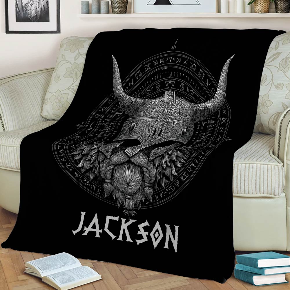 Black Viking blanket displayed on a sofa with an ornate horned helmet and Norse-inspired artwork