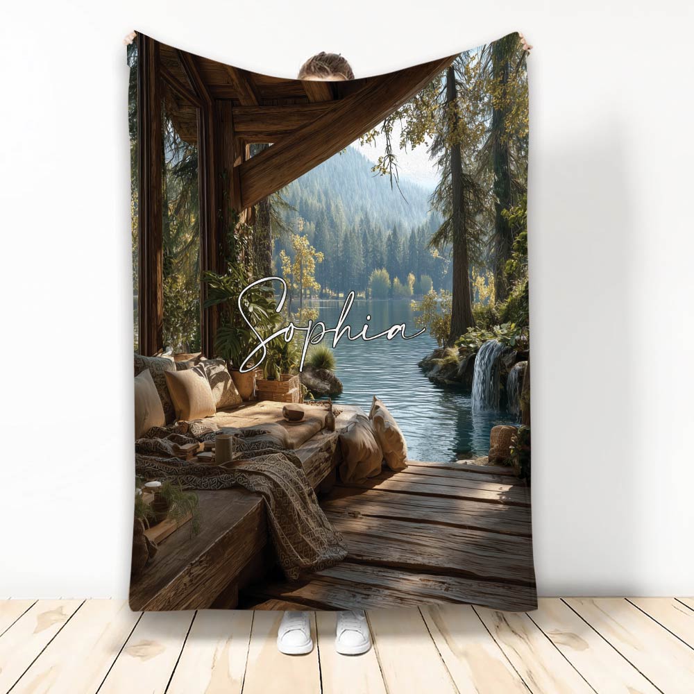 Lake house throw blanket featuring a rustic cabin deck, forest lake, waterfall, and mountain landscape