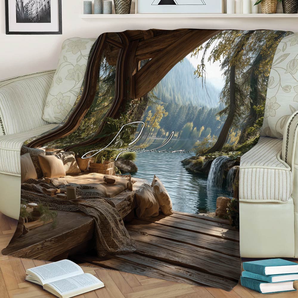 Close view of a lake house throw blanket showing a wooded lakeside cabin, dock, waterfall, and mountain view