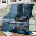 Rustic lake house blanket displayed on a sofa with winter woodland and lakeside cabin artwork