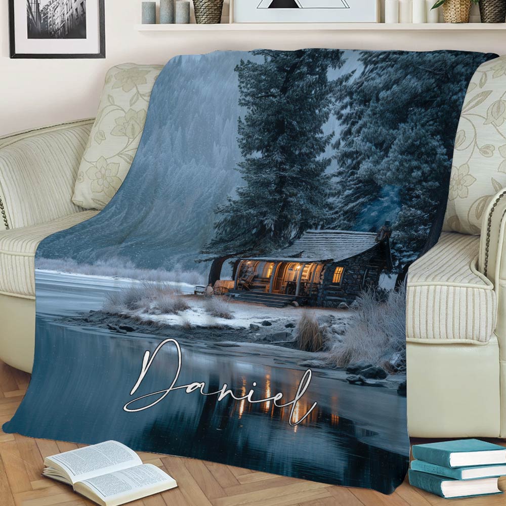 Rustic lake house blanket displayed on a sofa with winter woodland and lakeside cabin artwork
