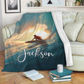 Surfing throw blanket draped over a sofa with expressive ocean wave and sunset artwork