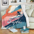 Colorful surfing blanket draped over a sofa with bold wave artwork and surfer silhouette