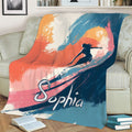 Surfing throw blanket displayed on a sofa with vibrant sunset-inspired wave artwork
