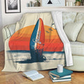 Surfboard beach throw blanket displayed on a sofa with retro sunset artwork and ocean waves
