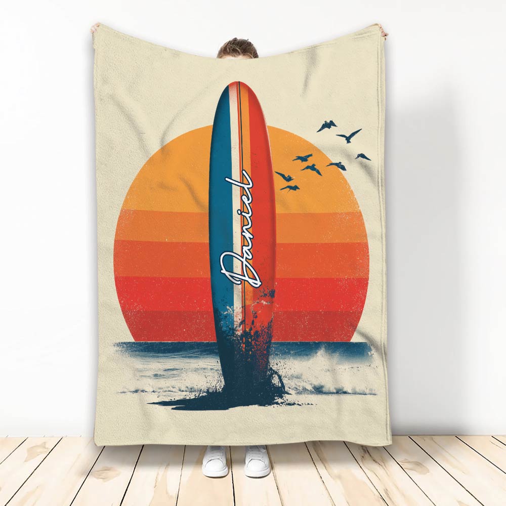 Surfing throw blanket with a colorful surfboard, ocean waves, sunset stripes, and flying seabirds