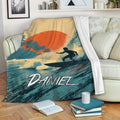 Surfing blanket displayed on a sofa with tropical wave artwork and a bold sunset color palette