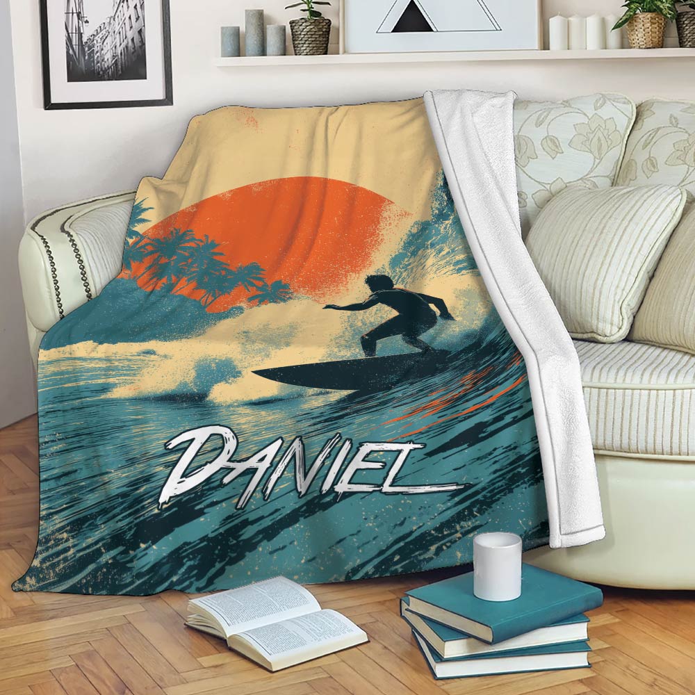 Surfing blanket displayed on a sofa with tropical wave artwork and a bold sunset color palette
