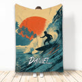 Surfing throw blanket with surfer riding a wave, tropical palms, and bold orange sunset artwork