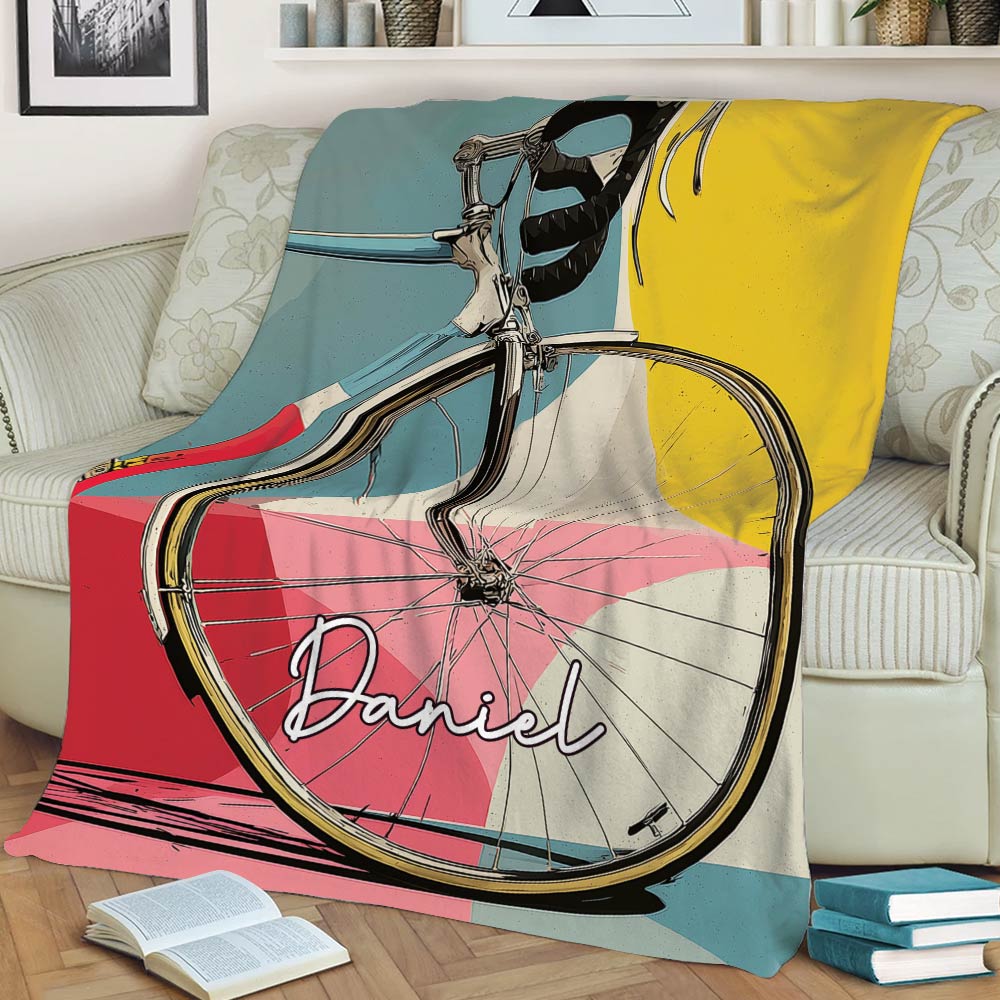 Colorful road bicycle blanket styled across a sofa with books and home decor