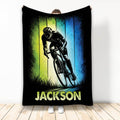 Custom bicycle throw blanket featuring a dynamic cyclist on a bike against vivid green and blue artwork