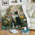 Floral tuxedo cat throw blanket displayed across a cozy sofa with books and pillows