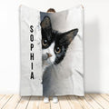Black and white tuxedo cat blanket shown hanging, featuring expressive cat artwork in gray and white tones
