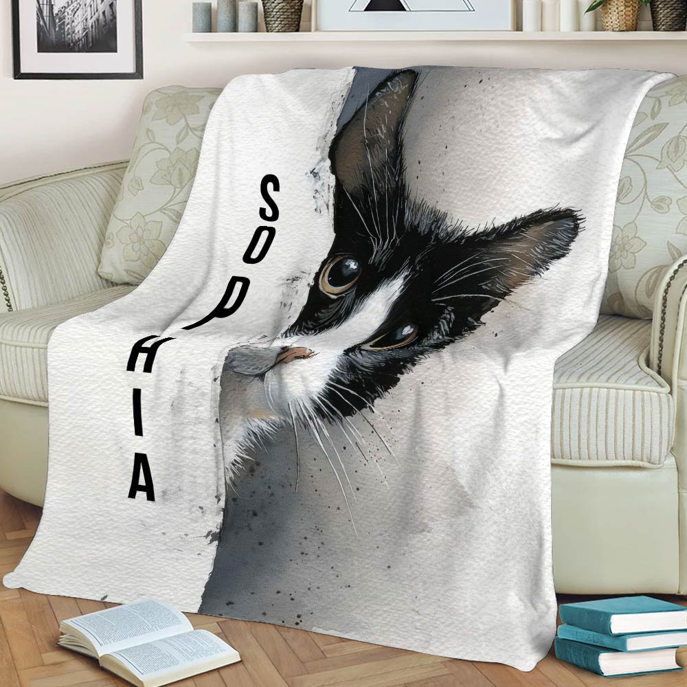Black and white tuxedo cat blanket styled across a sofa with a close view of the expressive cat illustration