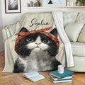 Black-and-white tuxedo cat throw blanket draped over a sofa in a cozy living room