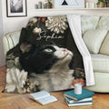 Black and white tuxedo cat blanket displayed on a sofa with books and home decor