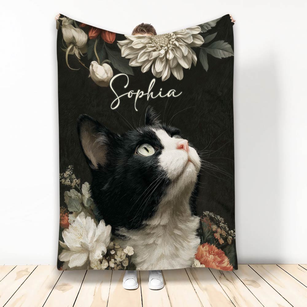 Tuxedo cat throw blanket with black and white floral artwork shown hanging in a room